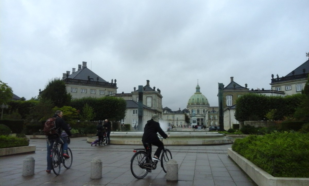 Personas en bicicleta, junto a una fuente, en el centro de Copenhague