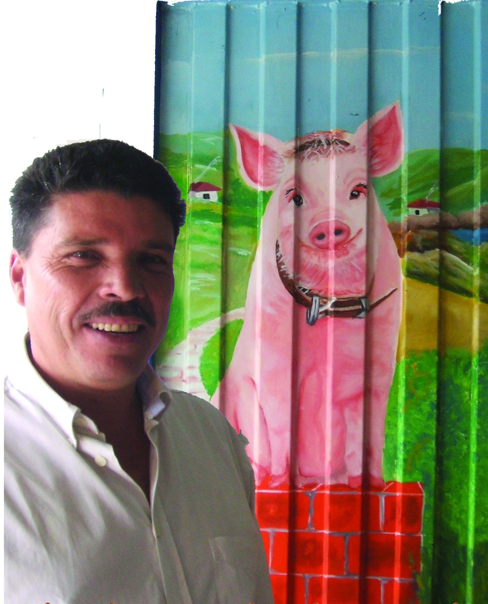 Fernando, de Surtilechona, posa junto a una puerta pintada con un cerdo sonriente