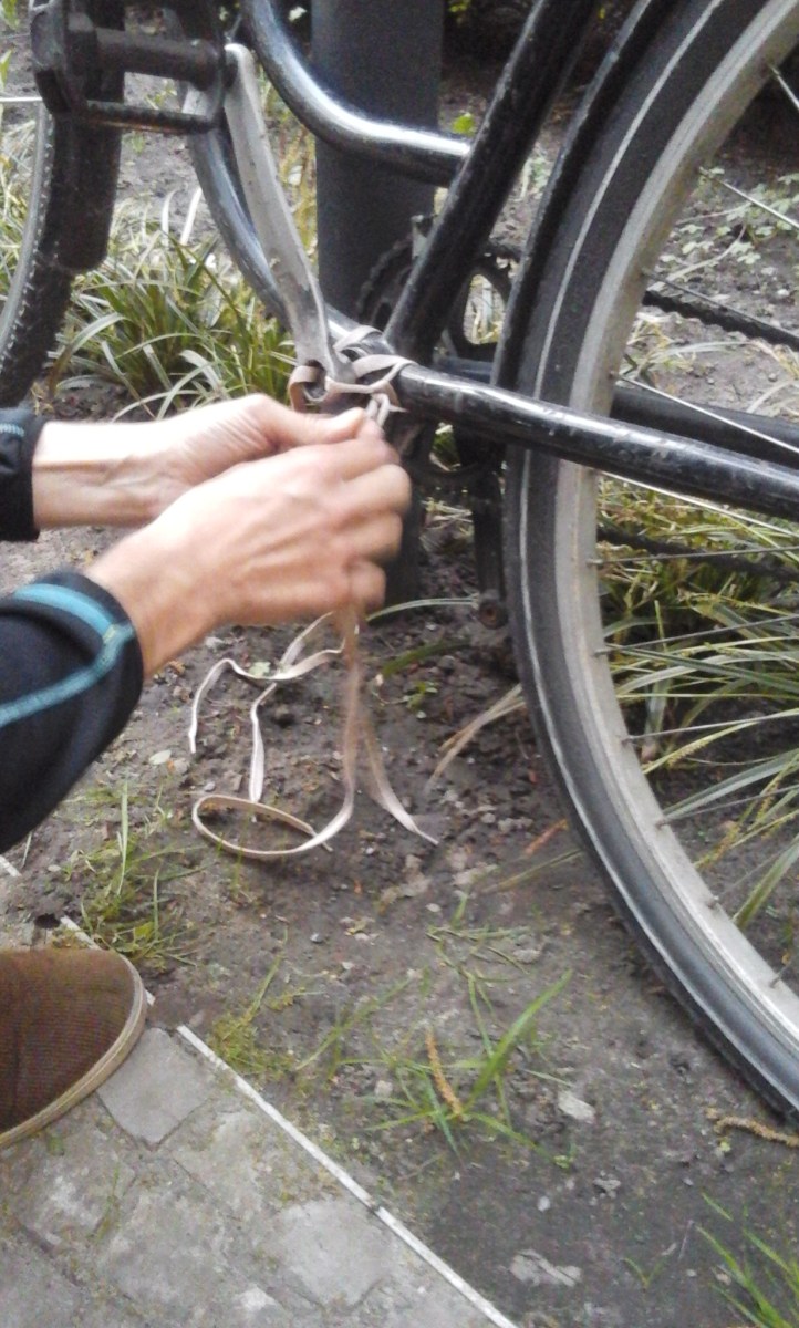 Manos arreglando el pedal dañado, con cordones