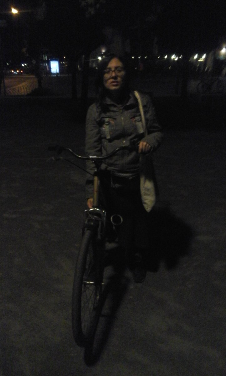 Mujer dudosa en bicicleta, por la noche