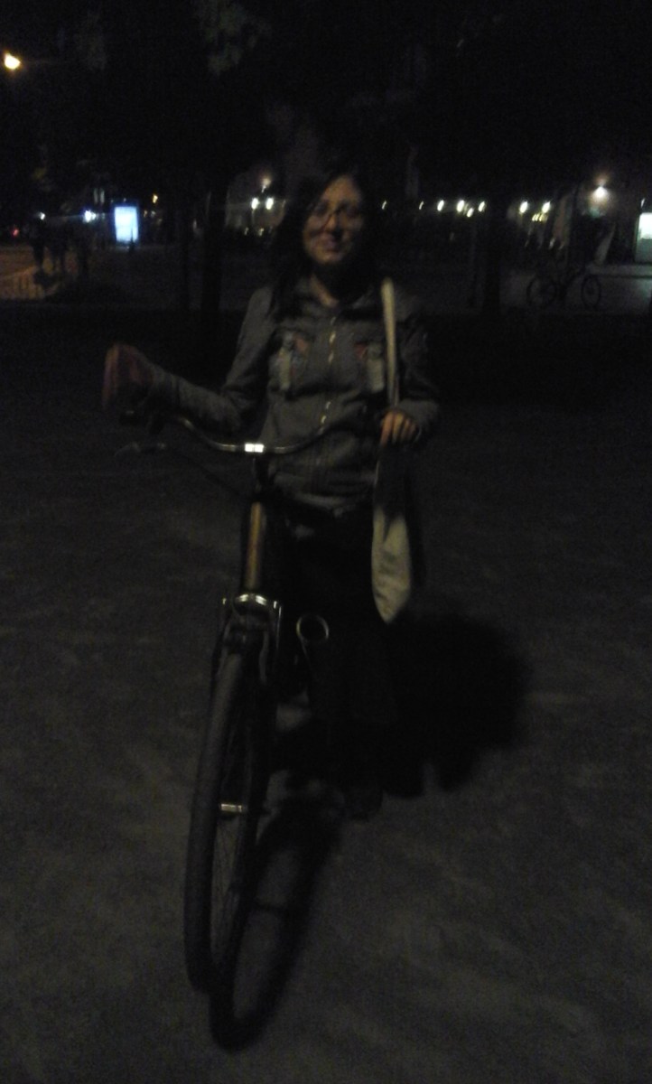 Mujer en bicicleta, por la noche