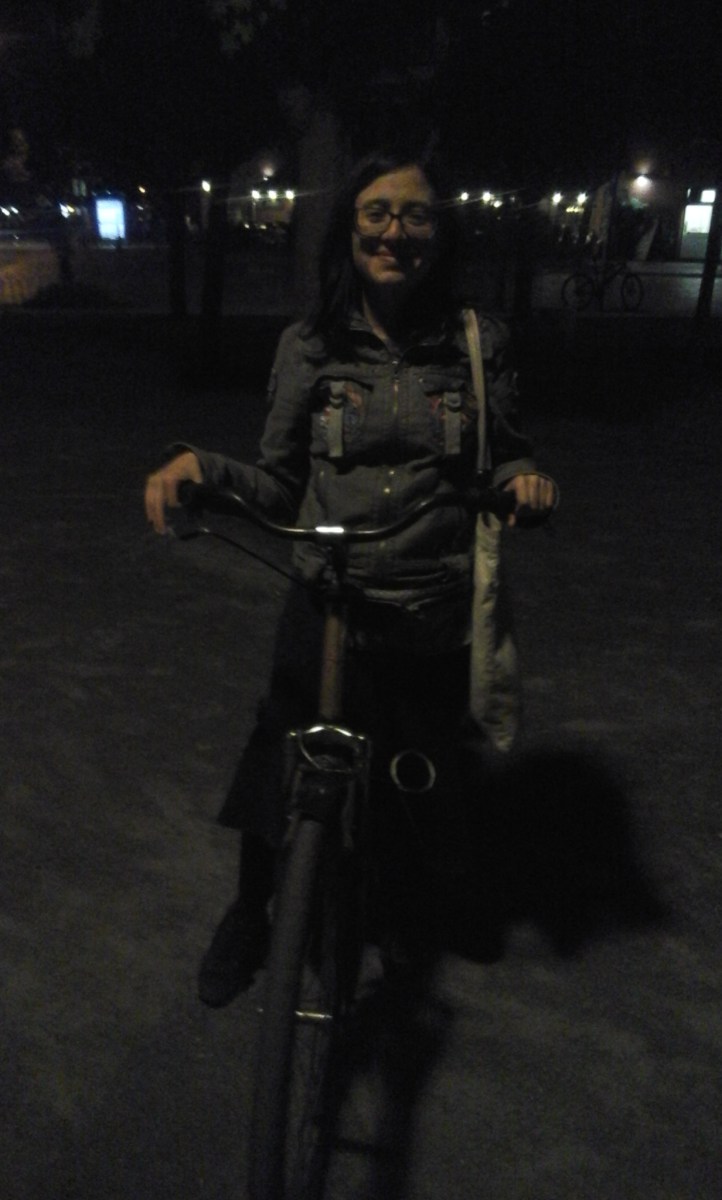 Mujer en bicicleta, en la noche