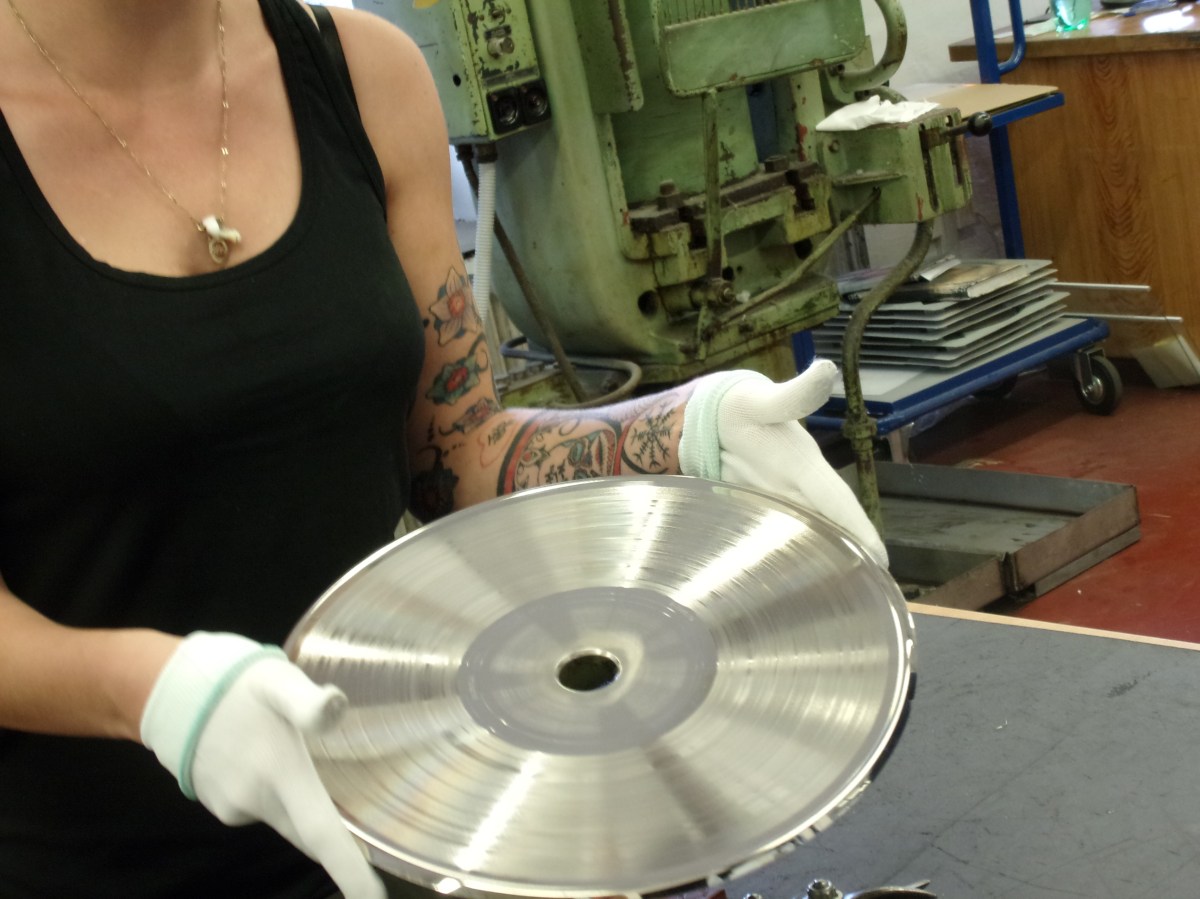 Trabajadora muestra el negativo del disco