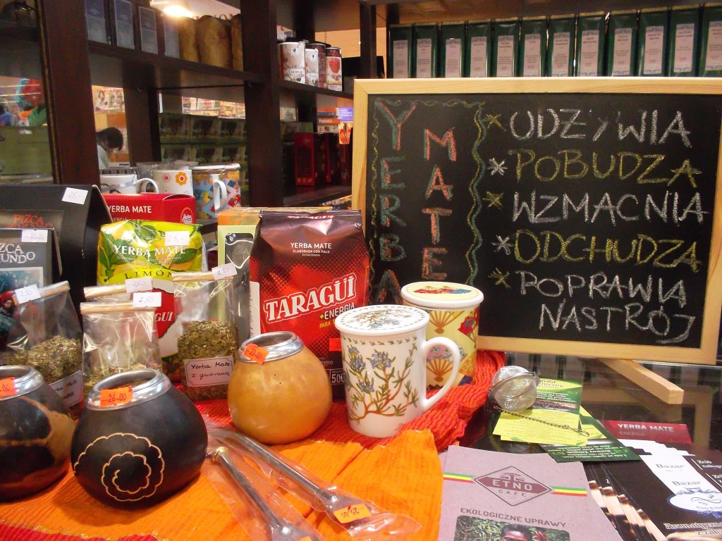 Productos de mate expuestos en un mercado: calabazas, bombillas, tazas, bolsas de Taragüí y Amanda, y un tablero con la leyenda descrita en el pie de foto.